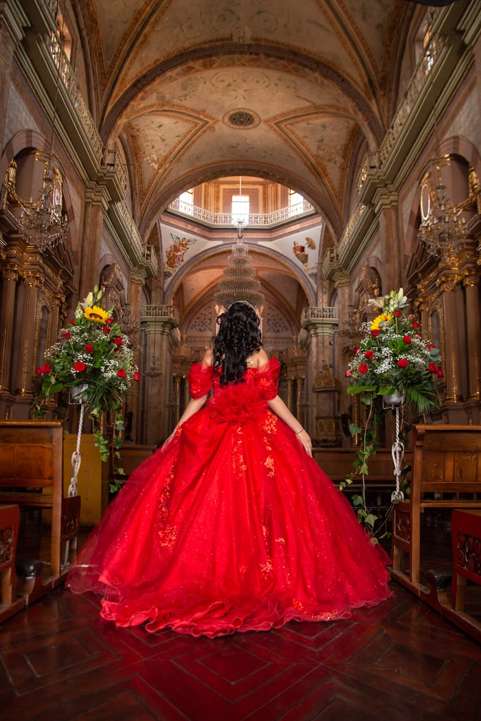 Captivating quinceañera in a vibrant red gown inside an ornate church in Guanajuato, Mexico.